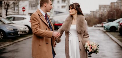 a man and a woman holding hands on a city street