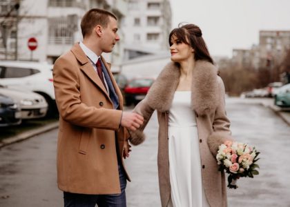 a man and a woman holding hands on a city street